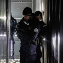 14 policajnt z bronią przeszukuje pomieszczenie